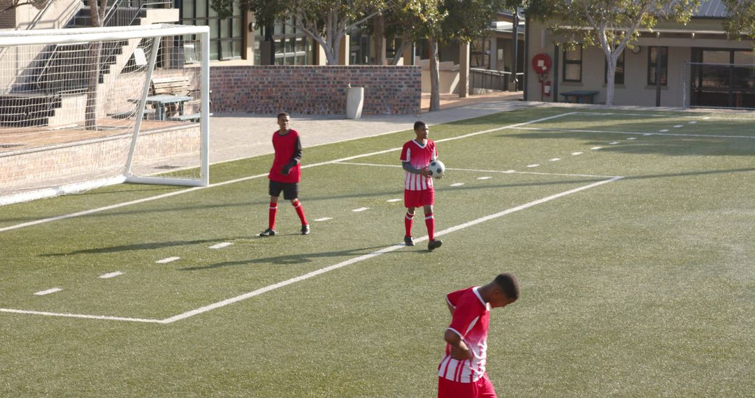 Young Soccer Players Practicing on Field in Sunshine