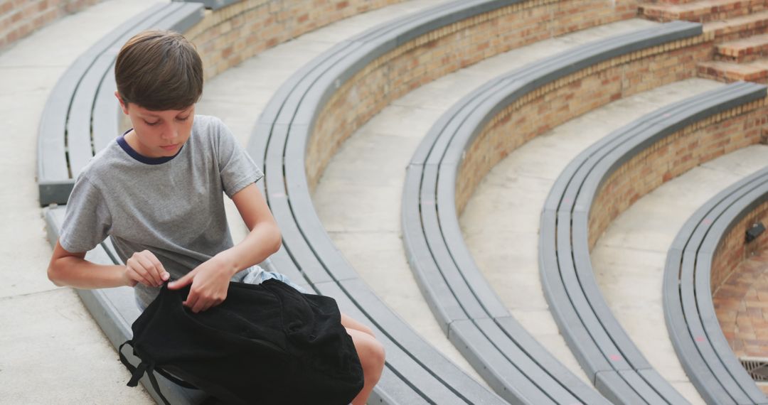 Youthful Solitude: Boy with Backpack in Architectural Amphitheater