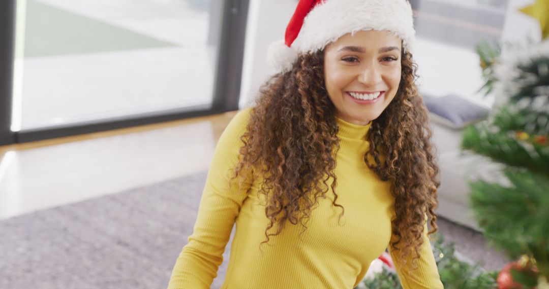 Smiling Woman Celebrating Christmas in Santa Hat - Free Images, Stock Photos and Pictures on Pikwizard.com