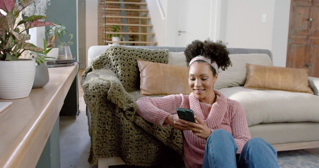 Woman Relaxing at Home Using Smartphone Next to Sofa - Free Images, Stock Photos and Pictures on Pikwizard.com