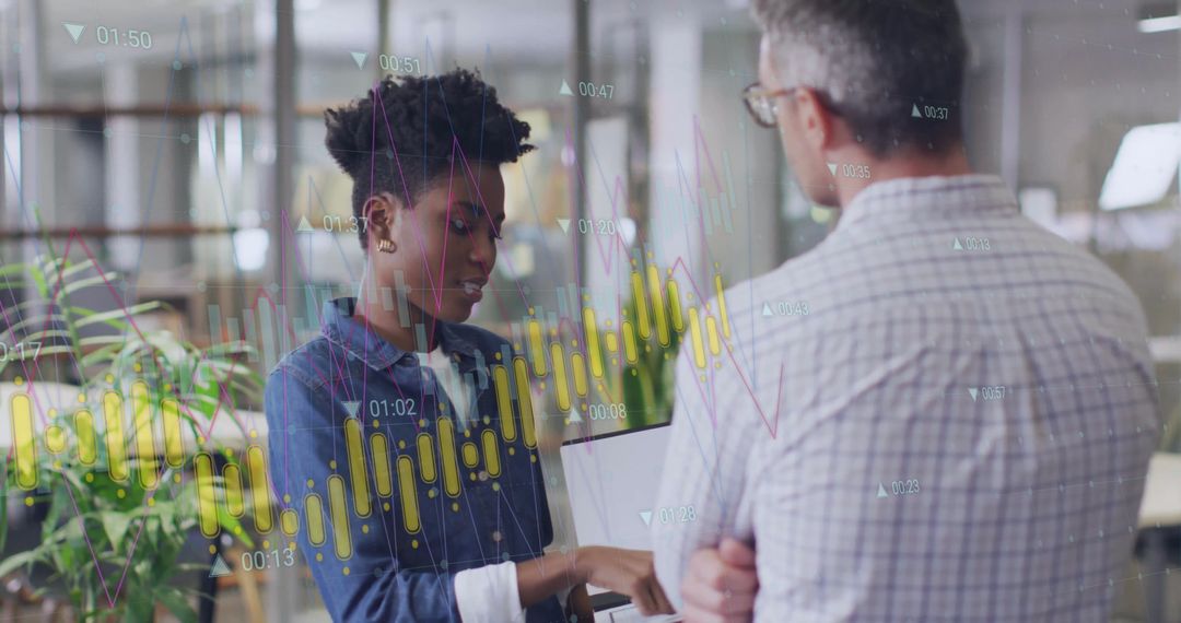 Diverse Colleagues Analyzing Data on Laptop in Modern Office Environment