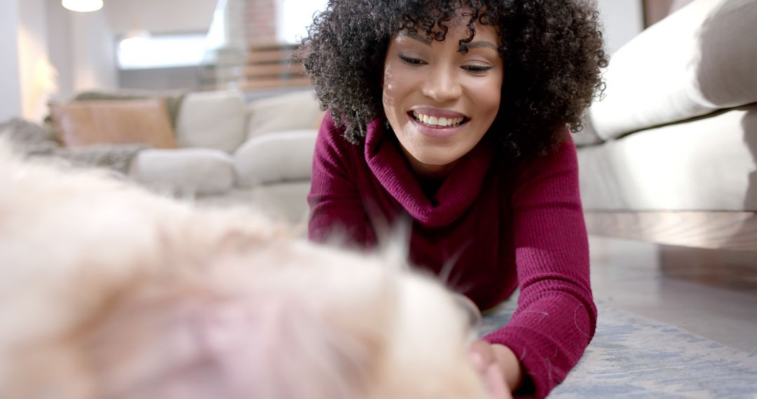 Smiling African American Woman Playing with Cute Dog Indoors - Free Images, Stock Photos and Pictures on Pikwizard.com