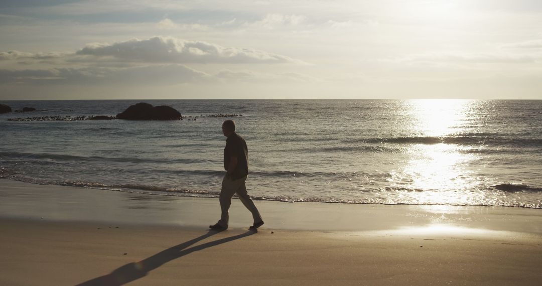 Man Walking on Beach During Sunset - Free Images, Stock Photos and Pictures on Pikwizard.com