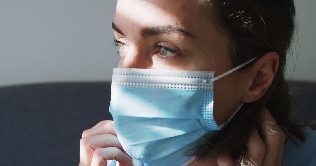 Woman Wearing Face Mask with Sunlight on Face During Pandemic - Free Images, Stock Photos and Pictures on Pikwizard.com