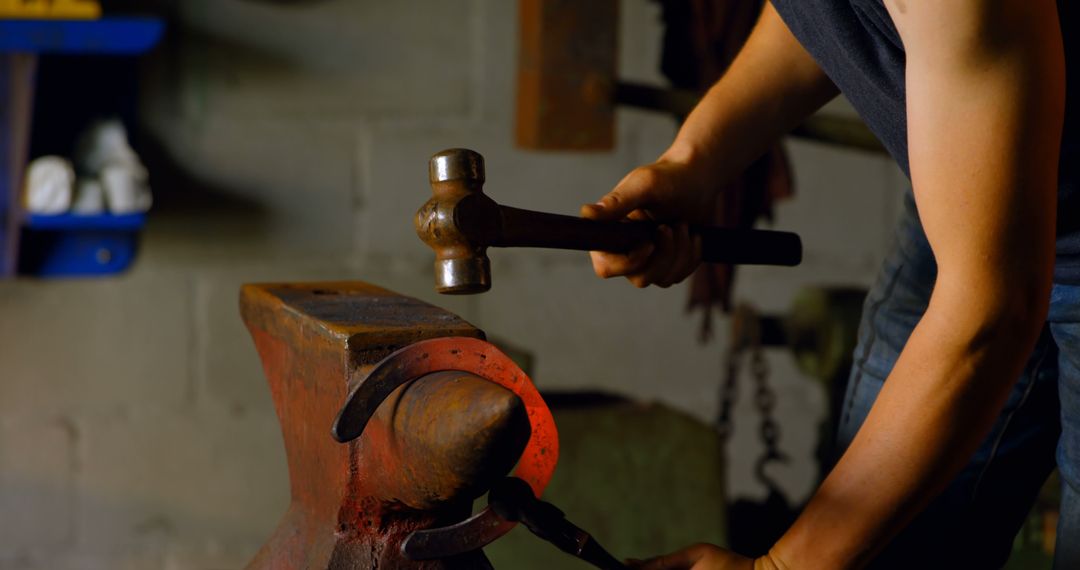 Blacksmith shaping heated metal on anvil in workshop - Free Images, Stock Photos and Pictures on Pikwizard.com