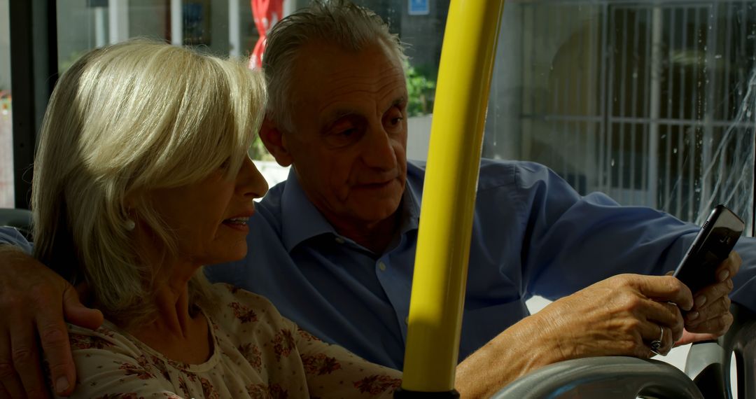 Senior Couple Engaging with Smartphone on City Bus