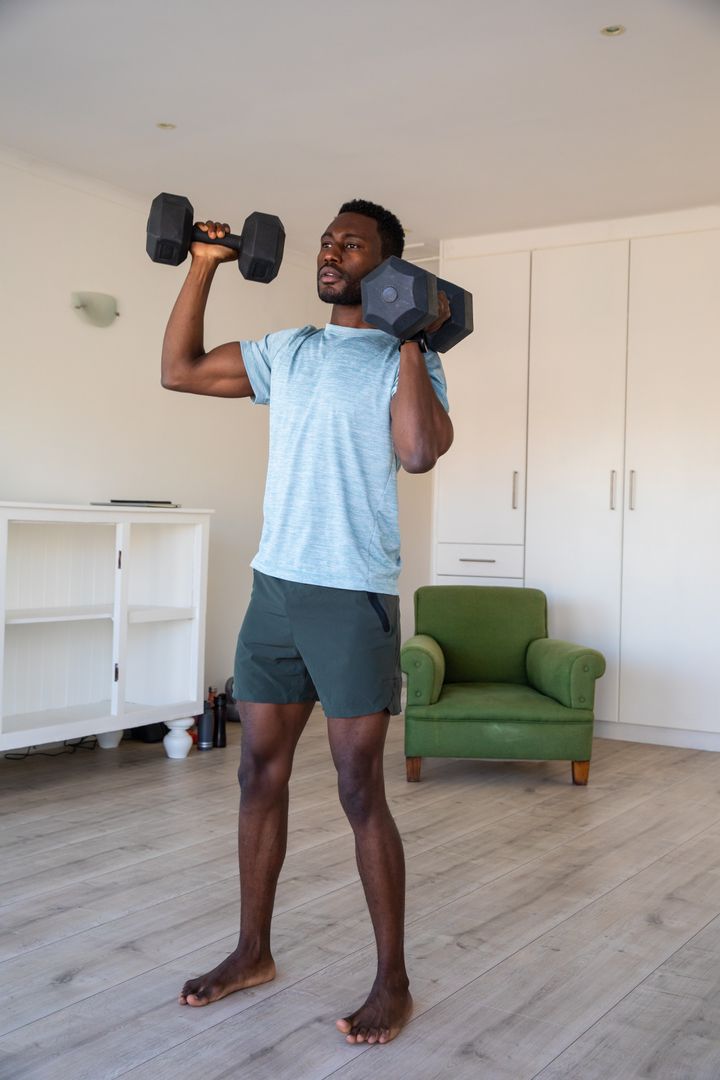 Man Lifting Dumbbells in Home Gym for Strength Training
