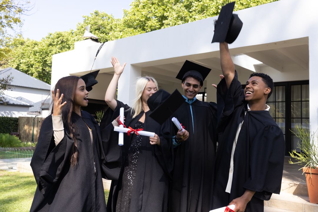 Diverse Graduates Celebrating Outdoors with Caps in Air