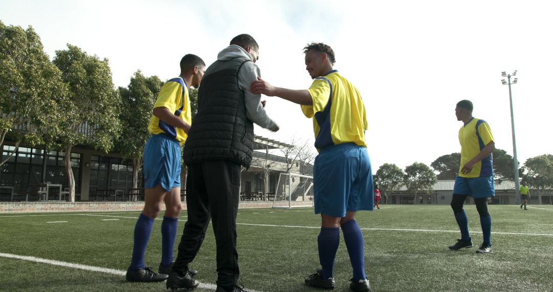 Coach Instructing Soccer Team during Practice on Field