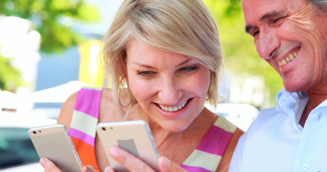 Smiling Middle-aged Couple Using Smartphones Outdoors - Free Images, Stock Photos and Pictures on Pikwizard.com