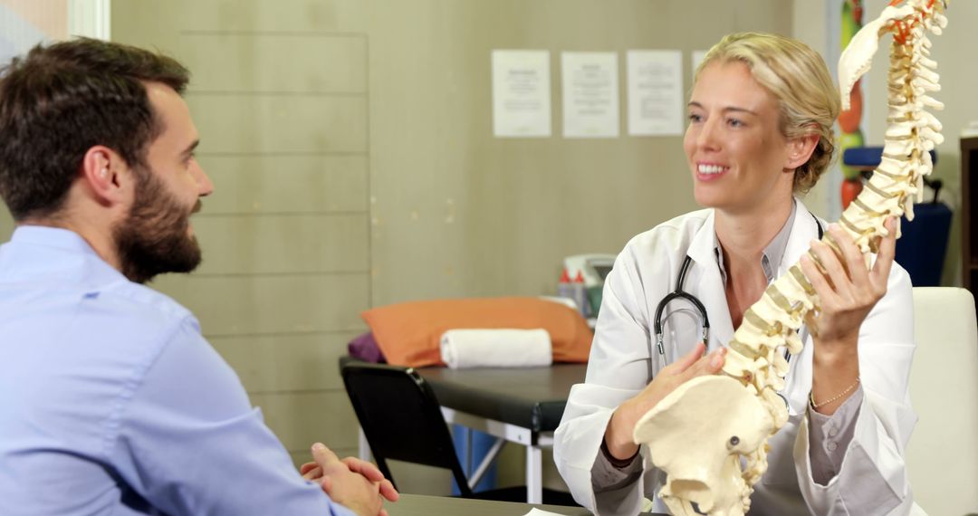 Doctor Explaining Spinal Anatomy to Male Patient in Medical Office - Free Images, Stock Photos and Pictures on Pikwizard.com