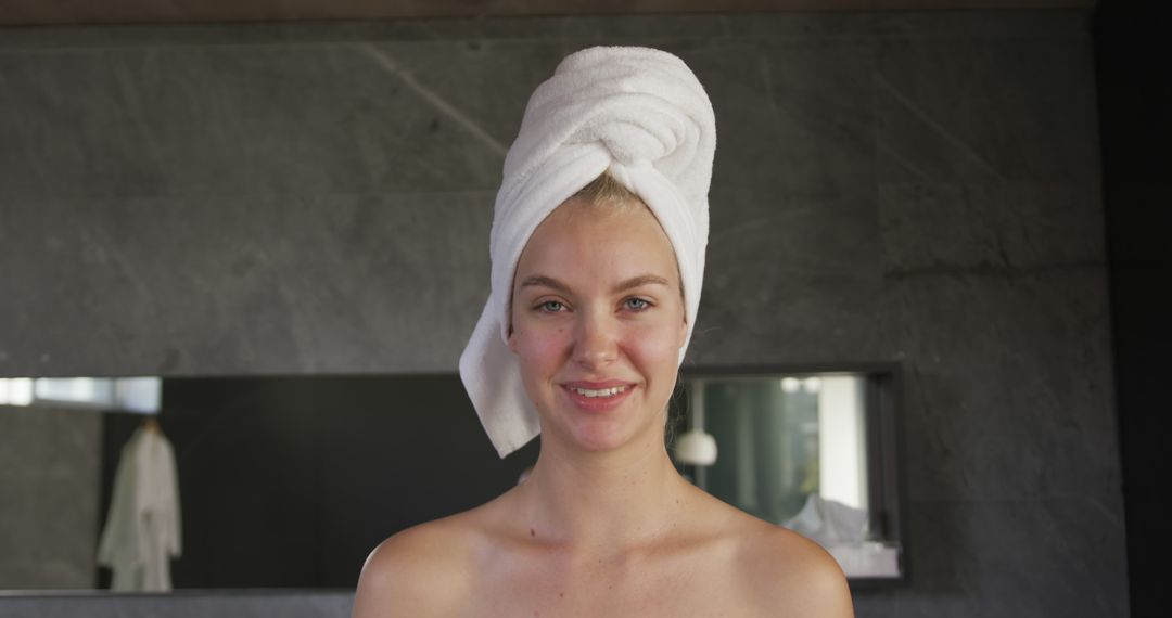 Smiling Woman with Towel Wrapped Around Hair in Modern Bathroom - Free Images, Stock Photos and Pictures on Pikwizard.com