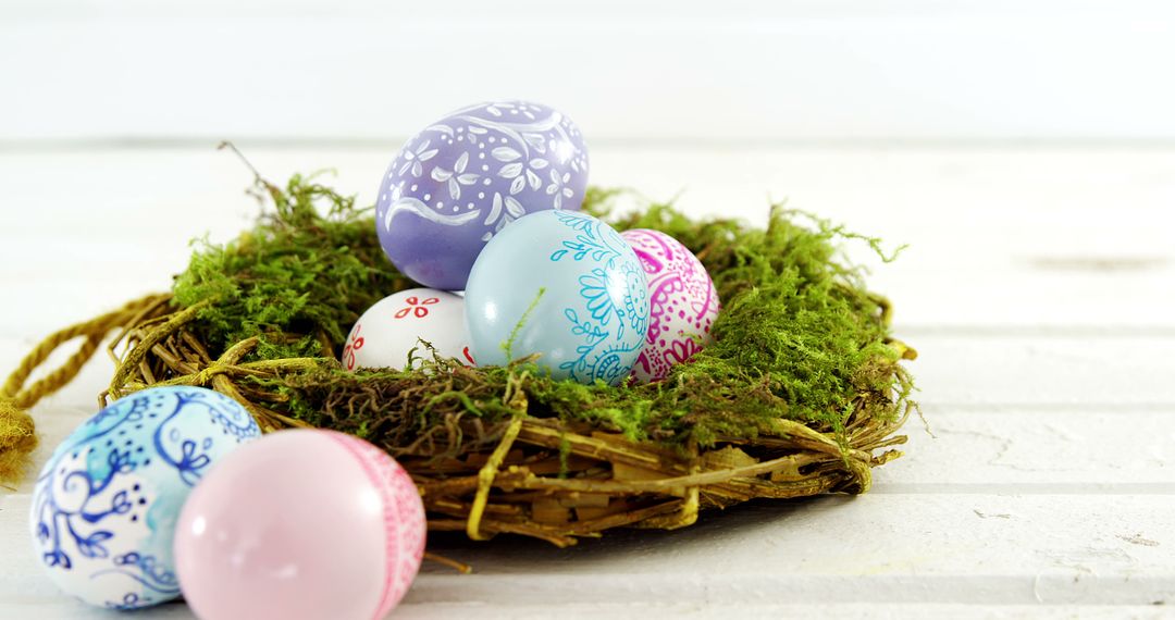A nest with colorful Easter eggs is set against a white wooden background, with copy space - Free Images, Stock Photos and Pictures on Pikwizard.com