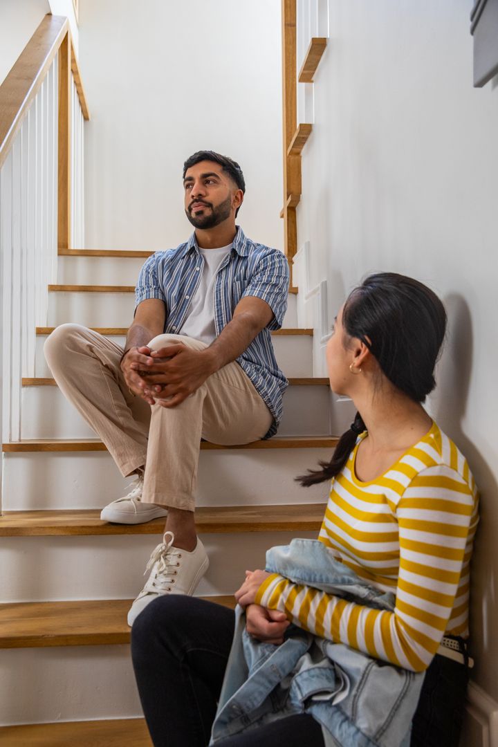 Couple Conversing on Modern Wooden Staircase