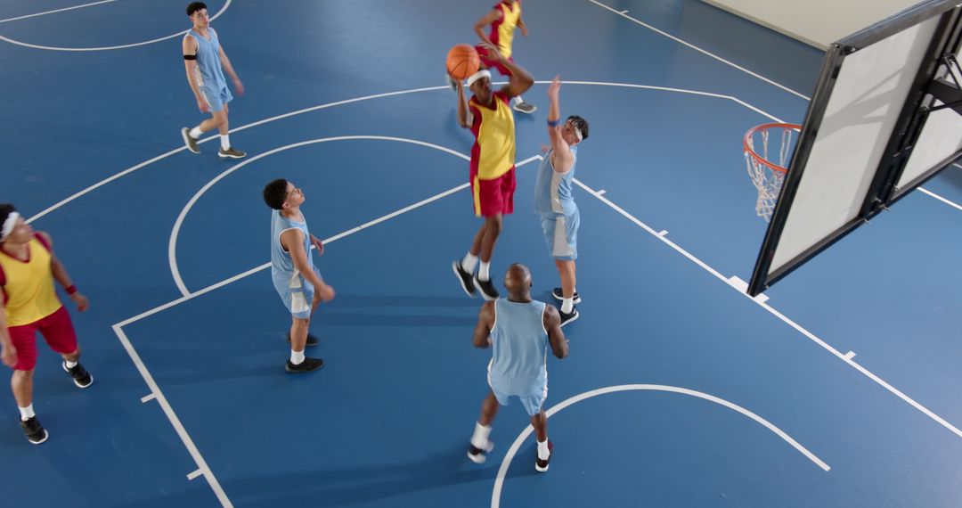 Intense Basketball Game with Leaping Shooter on Blue Court