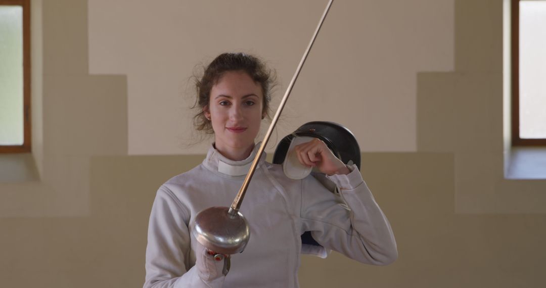 Confident Female Fencer with Epee in Gym Setting