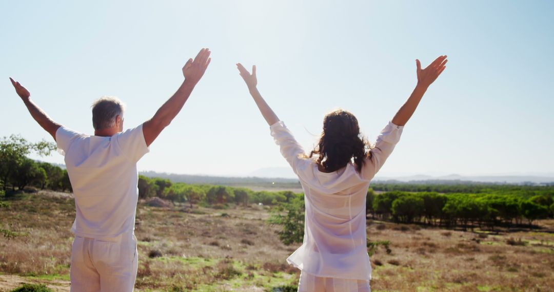 Couple Embracing the Outdoors with Open Arms in Sunny Field - Free Images, Stock Photos and Pictures on Pikwizard.com