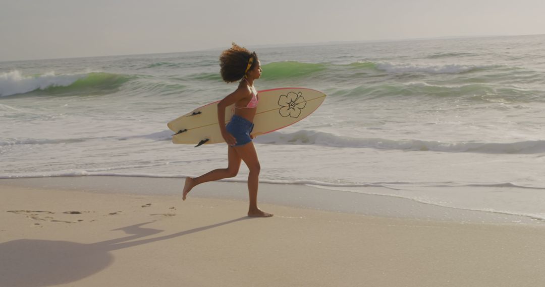 African American Female Surfer Running on Beach at Sunrise