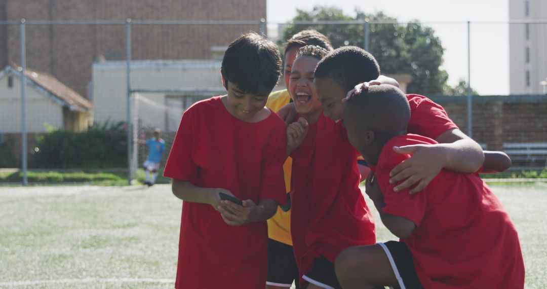 Diverse Kids Celebrating After Soccer Match with Smartphone - Free Images, Stock Photos and Pictures on Pikwizard.com