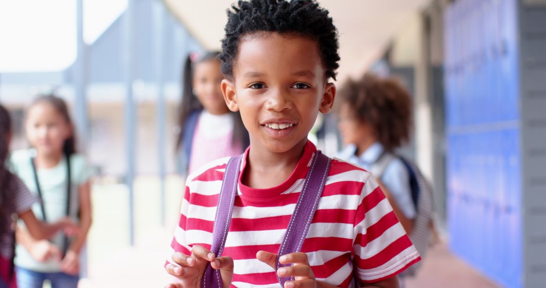 Smiling Boy Holding Backpack Straps Surrounded by Friends Outdoors