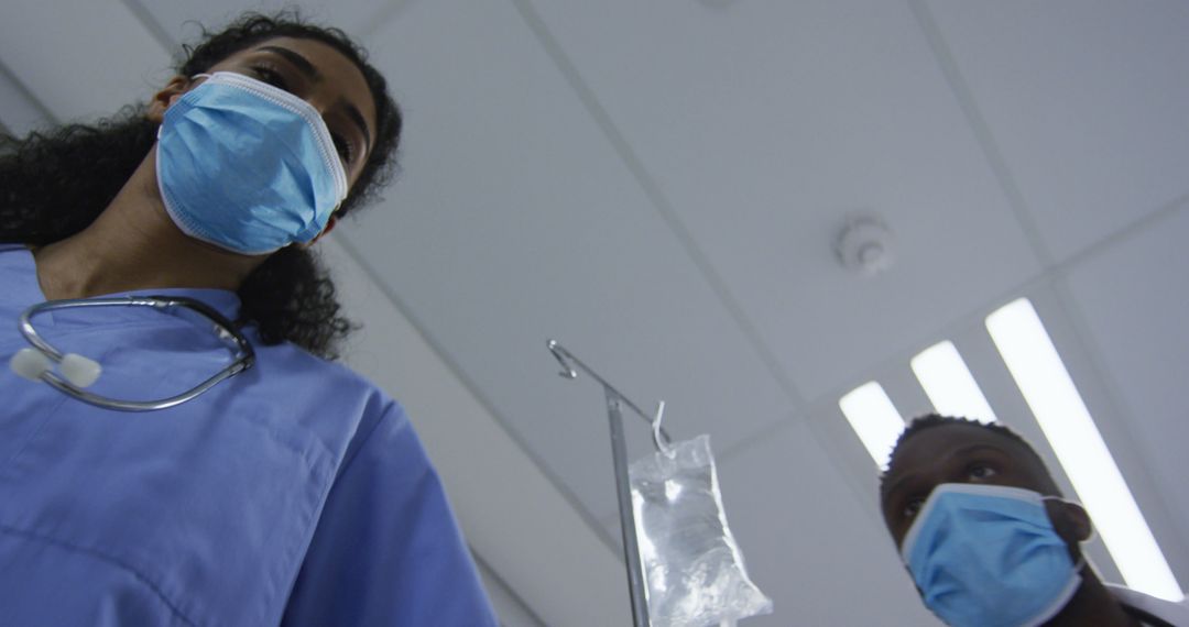 Medical Professionals Wearing Masks Administering IV Drip - Free Images, Stock Photos and Pictures on Pikwizard.com