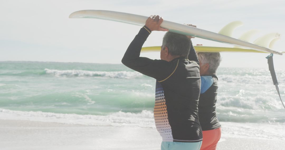 Senior Couple Enjoying Surfing Activity on Sunny Beach