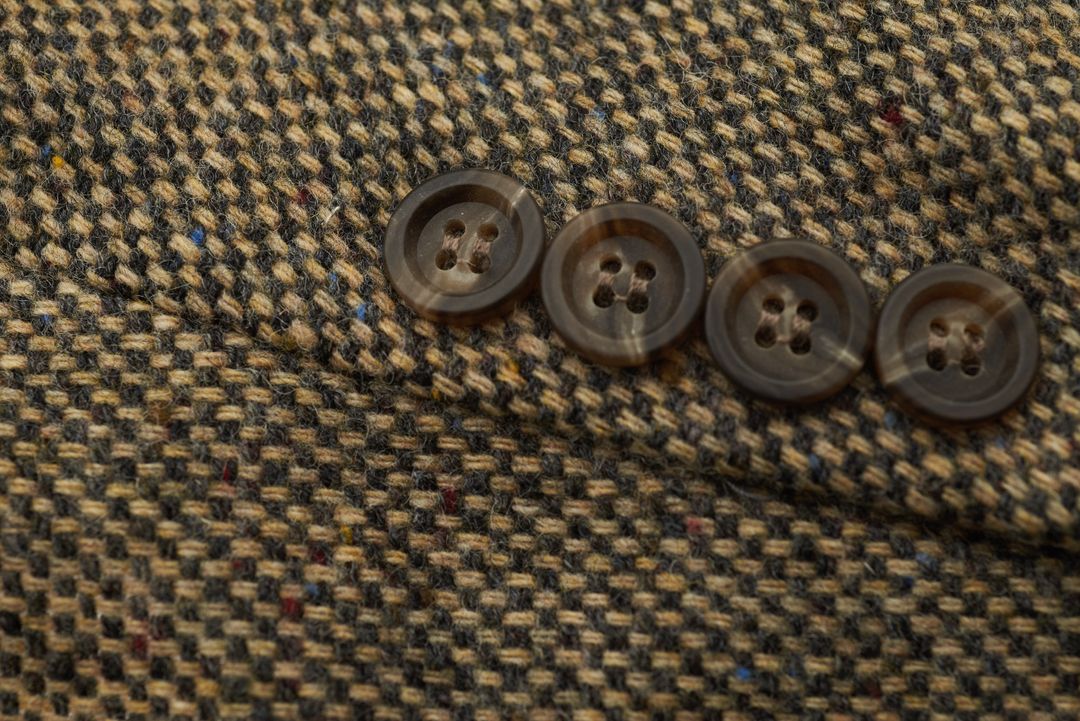 Rustic Brown Tweed Jacket Close-Up Showing Four Buttons and Textured Wool Fabric Detail