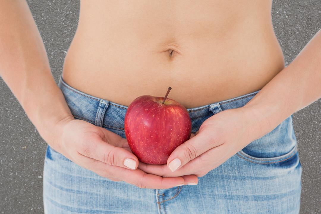 Midsection of woman holding apple representing weight loss - Free Images, Stock Photos and Pictures on Pikwizard.com