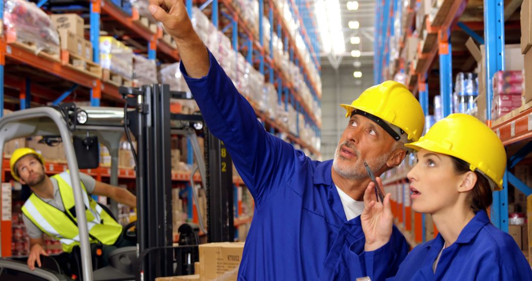 Warehouse Workers Supervising Inventory with Forklift Operator in Background - Free Images, Stock Photos and Pictures on Pikwizard.com