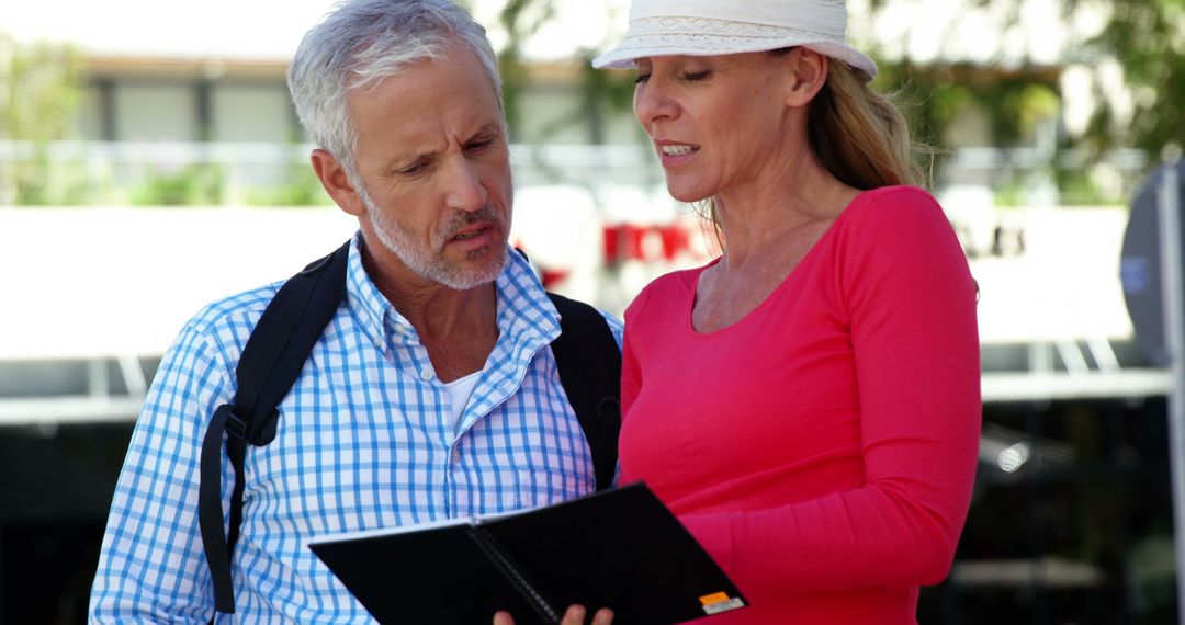 Mature Couple Exploring City with Guidebook on Sunny Day