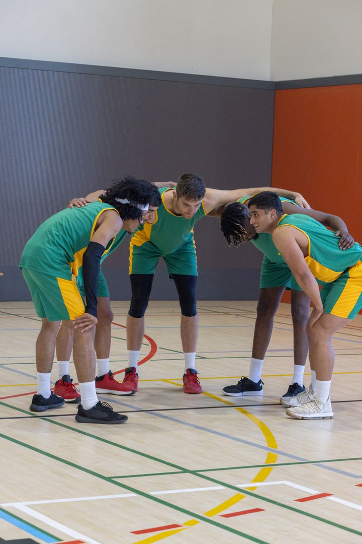 Diverse Basketball Team Huddling for Strategy on Indoor Court