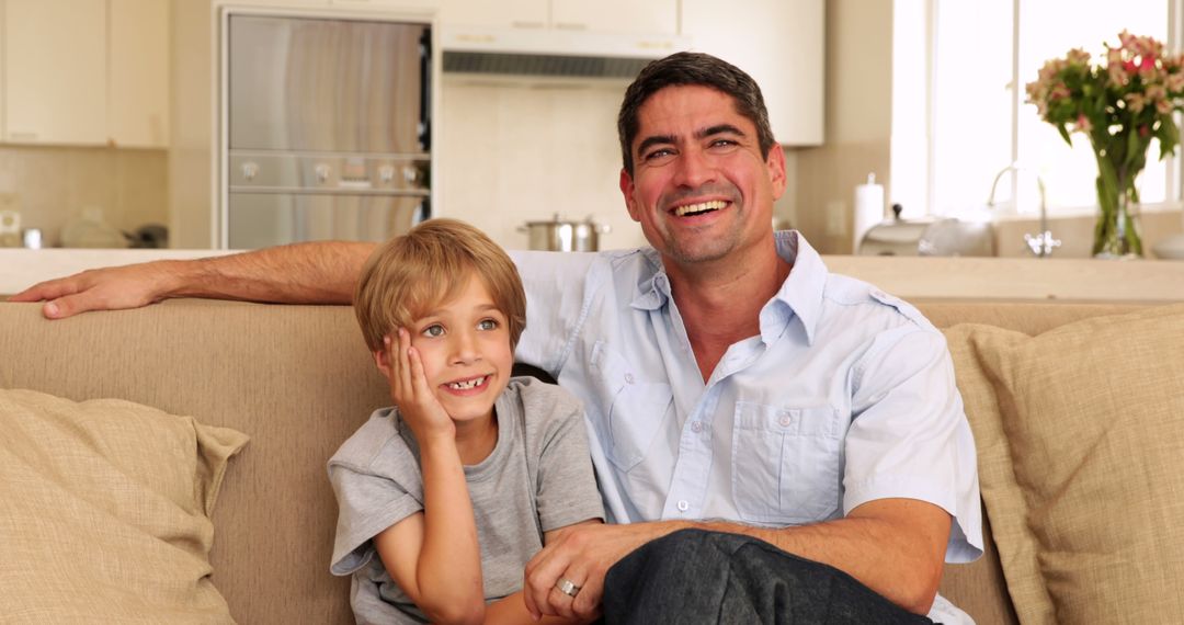 Father and Son Relaxing Together on Couch - Free Images, Stock Photos and Pictures on Pikwizard.com