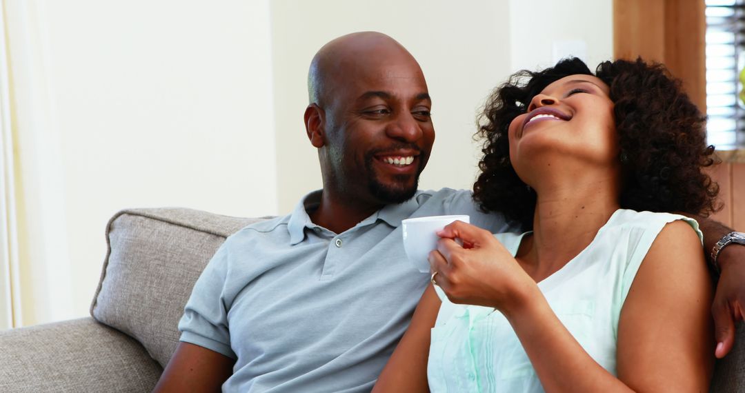 Couple Enjoying Relaxed Moment Together on Couch with Coffee