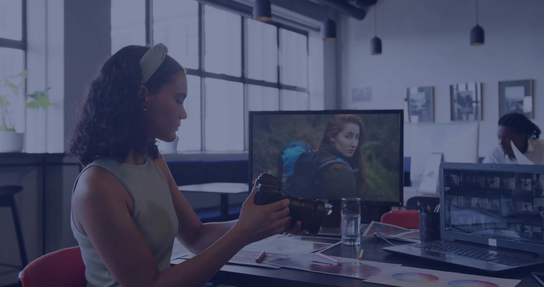 Professional Woman Adjusting DSLR Camera in Modern Office Workspace