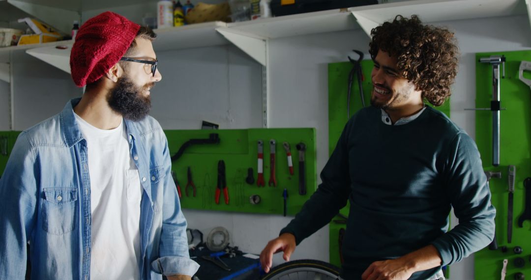 Two Young Men Having Conversation in Workshop with Repairs - Free Images, Stock Photos and Pictures on Pikwizard.com