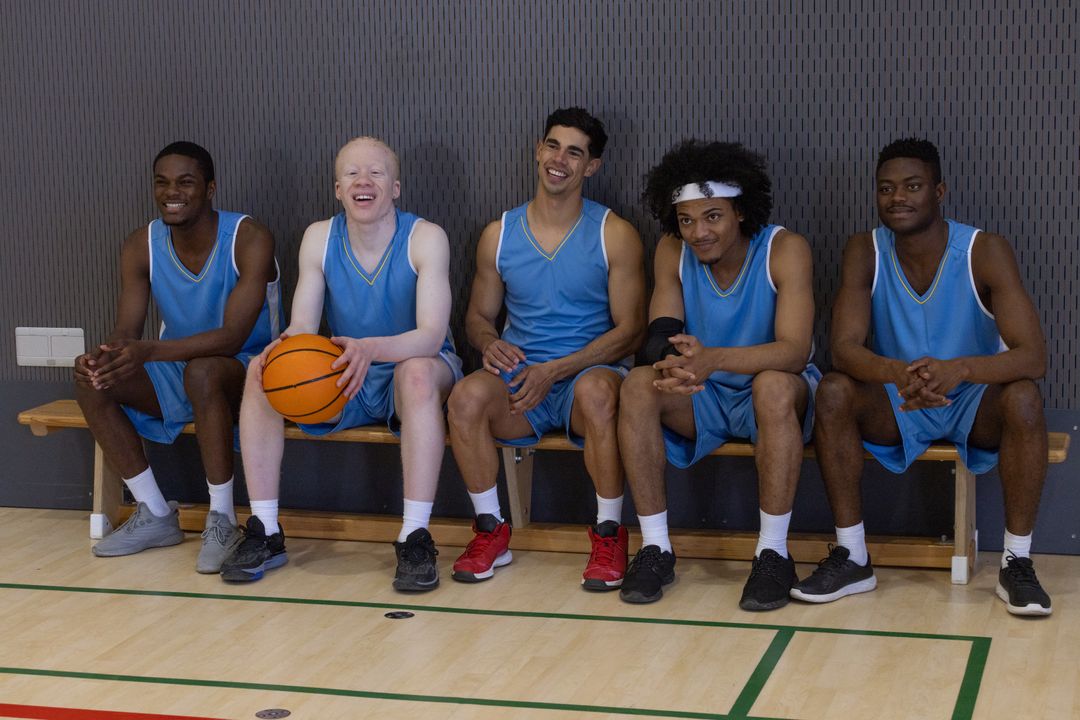 Diverse Basketball Team Relaxing on Bench in Gym