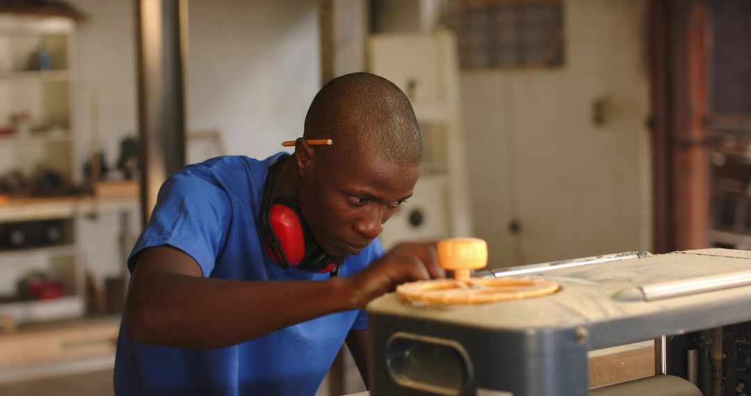 Focused Craftsman Using Table Saw in Workshop