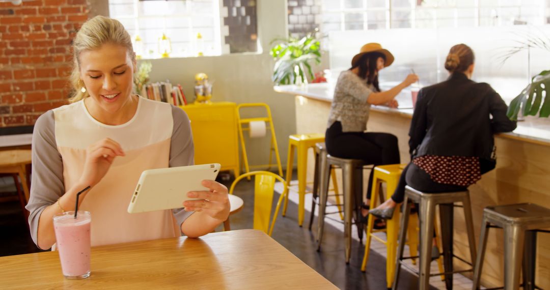 Woman Using Tablet in Bright Cozy Cafe - Free Images, Stock Photos and Pictures on Pikwizard.com