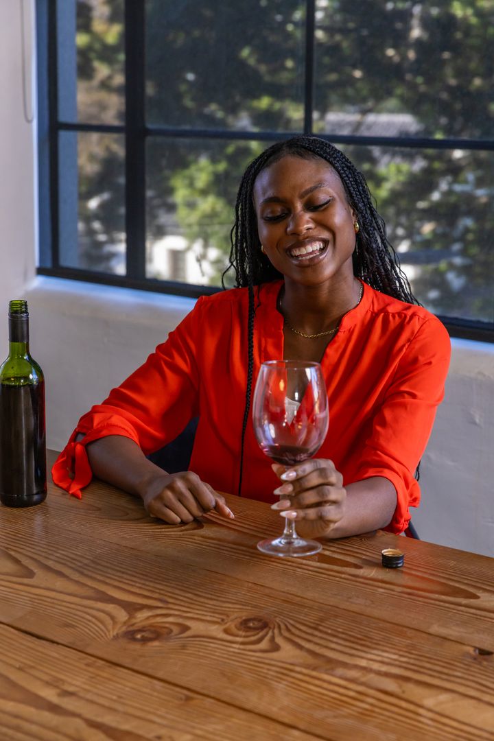 Elegant Woman Enjoying Wine in Vibrant Red Blouse