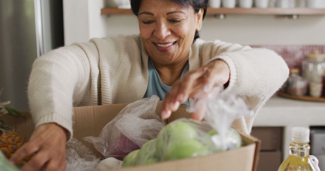 Smiling Senior Woman Unpacking Groceries in Kitchen - Free Images, Stock Photos and Pictures on Pikwizard.com