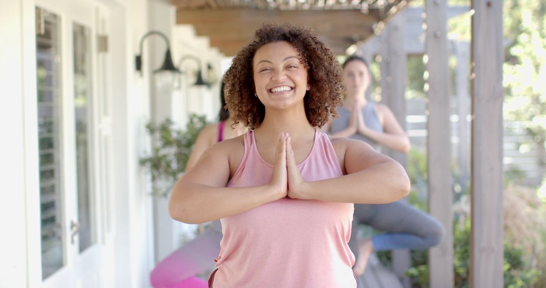 Friends Practicing Yoga Tree Pose on Patio for Wellness and Relaxation