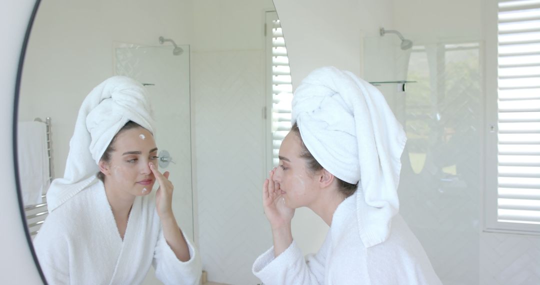 Woman in White Robe Applying Facial Cream in Bathroom - Free Images, Stock Photos and Pictures on Pikwizard.com