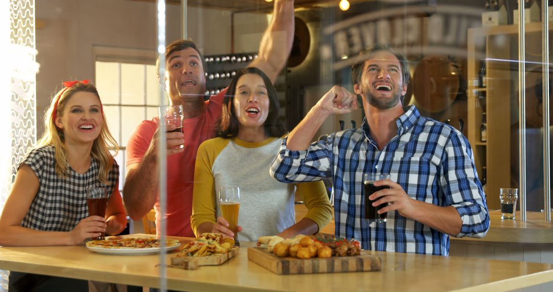 Excited Friends Enjoying Pizza and Drinks While Watching Game