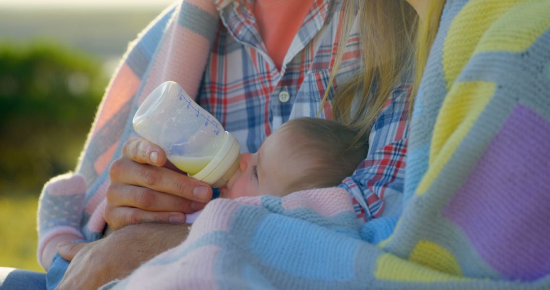 Mother Feeding Baby with Bottle Outdoors on Cozy Blanket - Free Images, Stock Photos and Pictures on Pikwizard.com