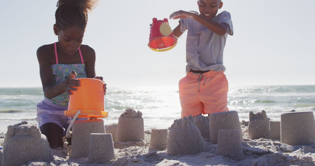 Children Building Sandcastles on Sunny Beach - Free Images, Stock Photos and Pictures on Pikwizard.com