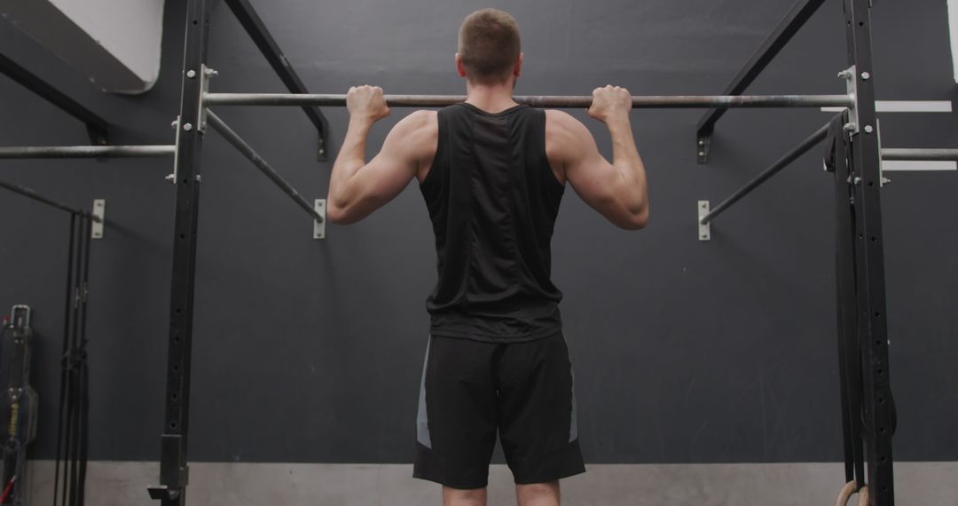 Athletic Man Performing Chin Ups at Gym for Strength Training
