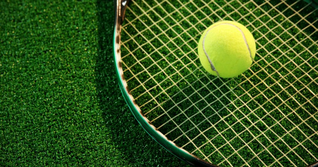 Tennis Ball on Racket Eldge on Green Court Surface - Free Images, Stock Photos and Pictures on Pikwizard.com