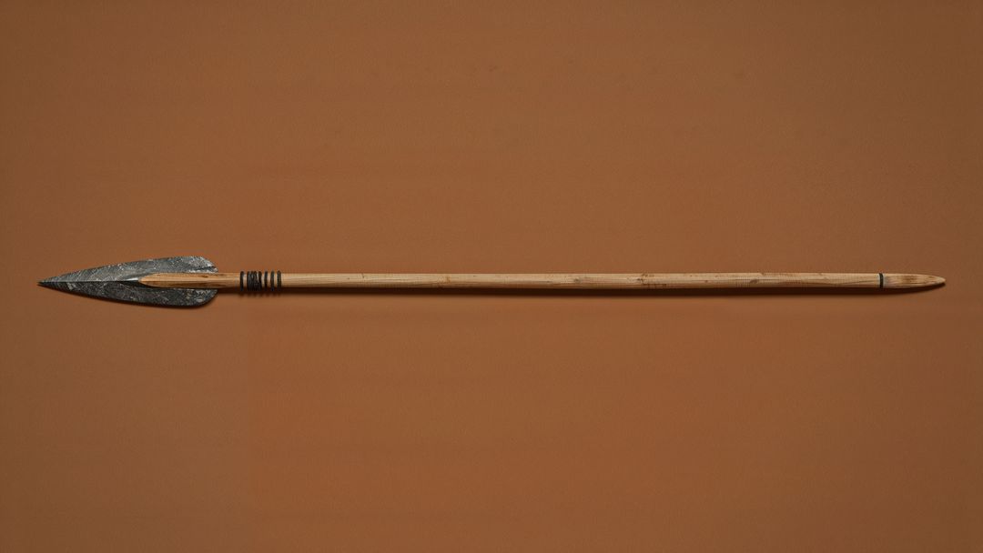 Caveman spear with stone tip on brown background