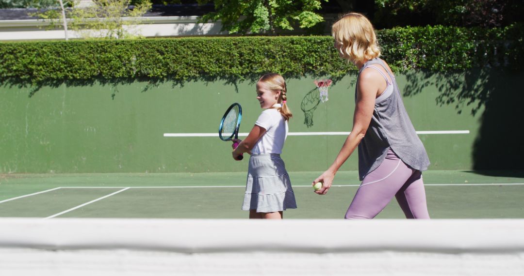 Caucasian mother teaching her daughter to play tennis at tennis court on a bright sunny day - Free Images, Stock Photos and Pictures on Pikwizard.com