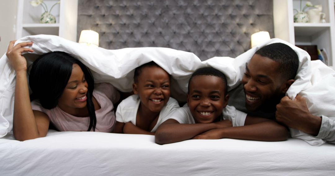 Happy African American Family Enjoying Morning in Bed Together - Free Images, Stock Photos and Pictures on Pikwizard.com